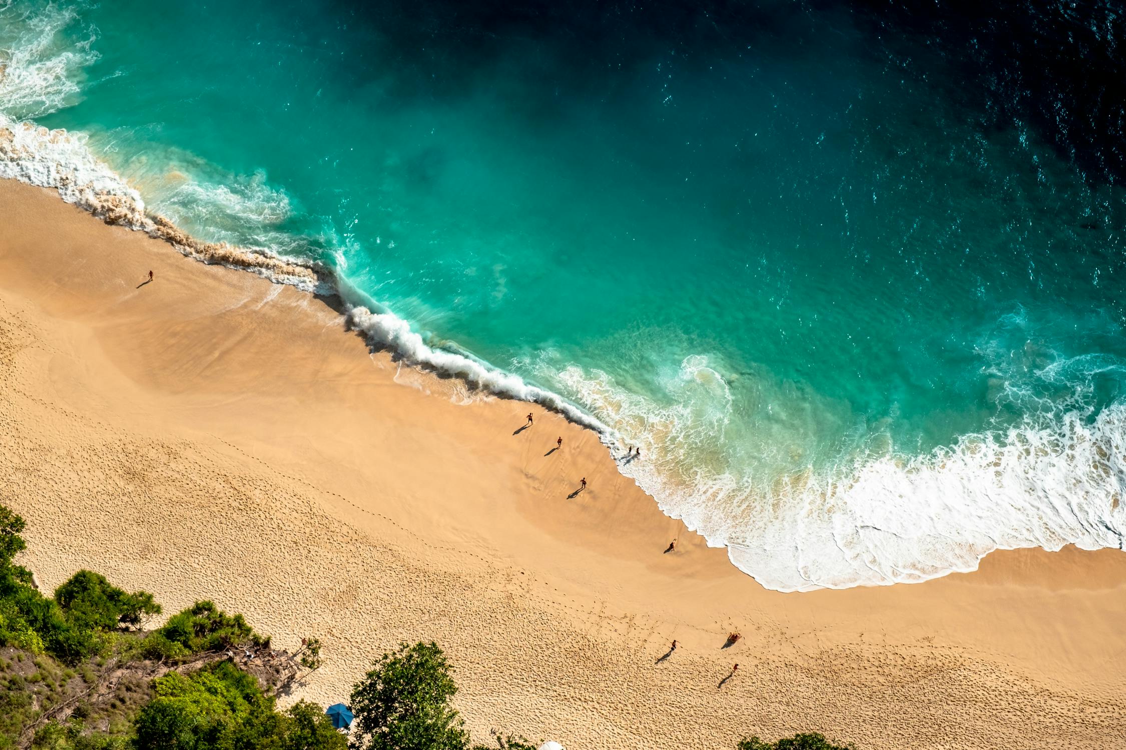 Sandy shores of Kuta Beach in Bali, bustling with surfers. Enjoy beach activities during your Bali vacation.