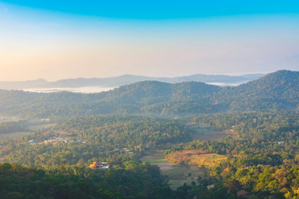 Mist-covered mountains in Coorg during sunrise