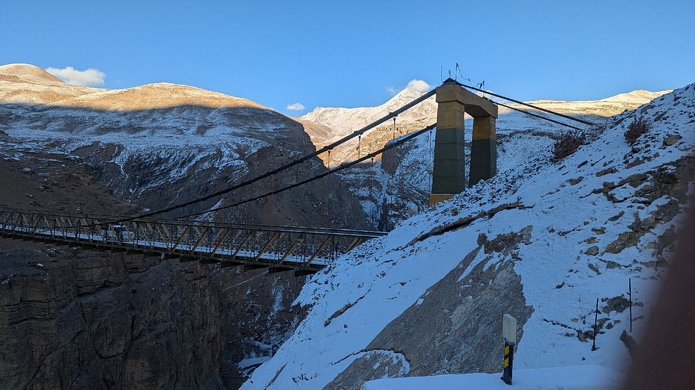 Indian Himalayas, The snow-capped summit of Mount Kanchenjunga towering over alpine valleys under a bright winter sky.