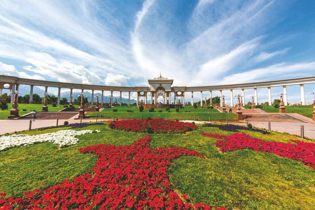 Scenic nature trail in Almaty surrounded by beautiful flowers and alpine mountain peaks