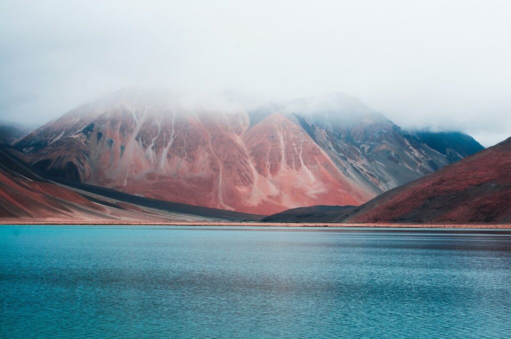 Experience the breathtaking natural phenomenon where two mighty rivers collide amidst the towering Himalayan mountains. This aerial drone footage captures the stunning confluence of the Indus and Zanskar Rivers near Leh, Ladakh, India.