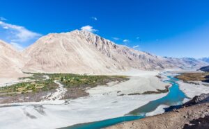 Experience the breathtaking natural phenomenon where two mighty rivers collide amidst the towering Himalayan mountains. This aerial drone footage captures the stunning confluence of the Indus and Zanskar Rivers near Leh, Ladakh, India.