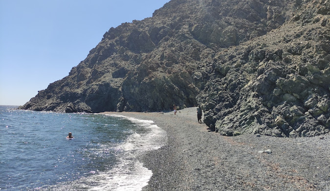 Black pebble beach in Samothraki, Greece, with crystal clear waters. Discover unique beaches on our travel blog.