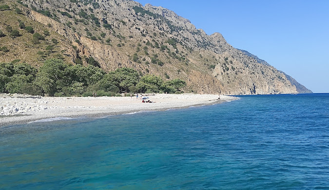 Turquoise waters and a beautiful beach in Samothraki, Greece, surrounded by mountains. Find travel inspiration for Samothraki here.