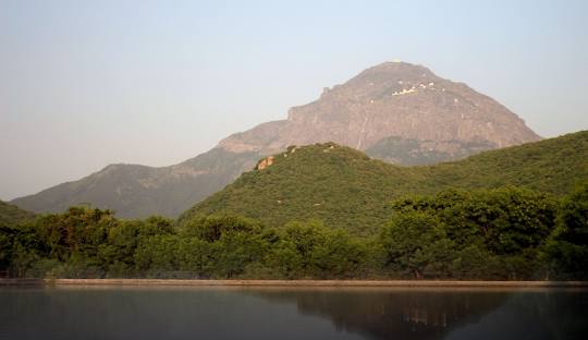 View of Girnar Hill range with greenery and water body at the base