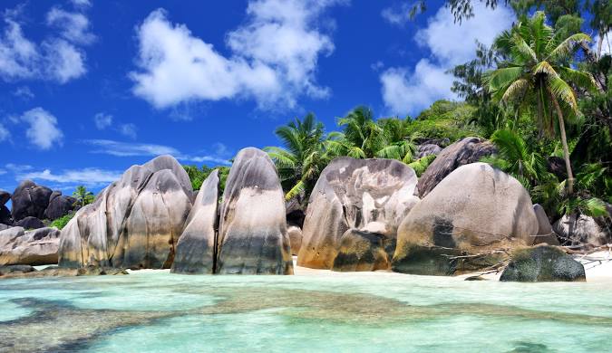 Iconic Seychelles beach with dramatic granite boulders contrasting against the white sand and vibrant turquoise water. A classic image for travel blog articles inspiration, highlighting the beauty of Seychelles.