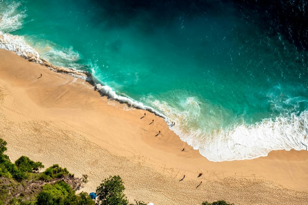 Sandy shores of Kuta Beach in Bali, bustling with surfers. Enjoy beach activities during your Bali vacation.