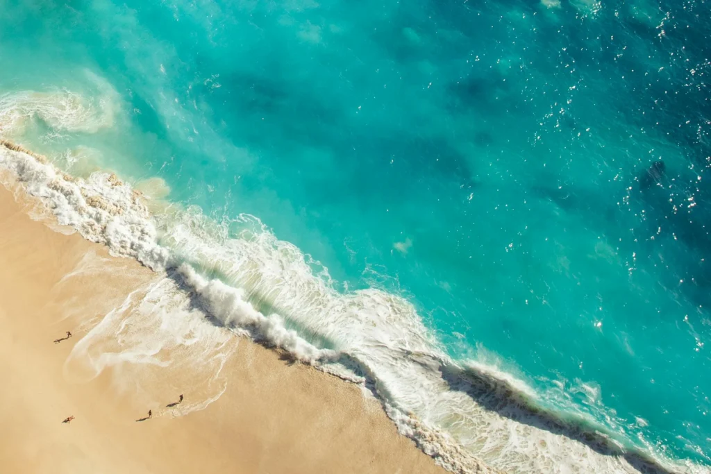 Sandy shores of Kuta Beach in Bali, bustling with surfers. Enjoy beach activities during your Bali vacation.