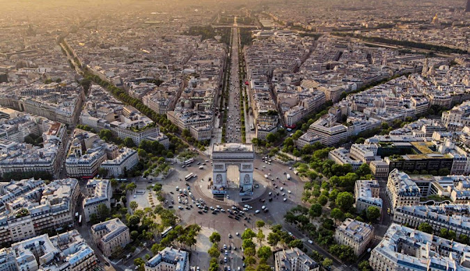 High aerial photograph capturing the Arc de Triomphe and the radiating avenues of Place Charles de Gaulle (Étoile) in Paris.