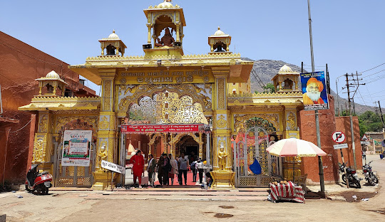 Golden temple gate with visitors at the entrance of Girnar Hills in Junagadh, Gujarat