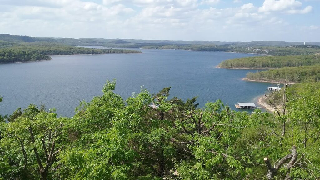 Panoramic vista of the Ozark Mountains and a lake from a viewpoint in Mark Twain National Forest. Capture breathtaking views during your Ozark National Forest hiking trip, showcasing the vastness of the Missouri landscape.