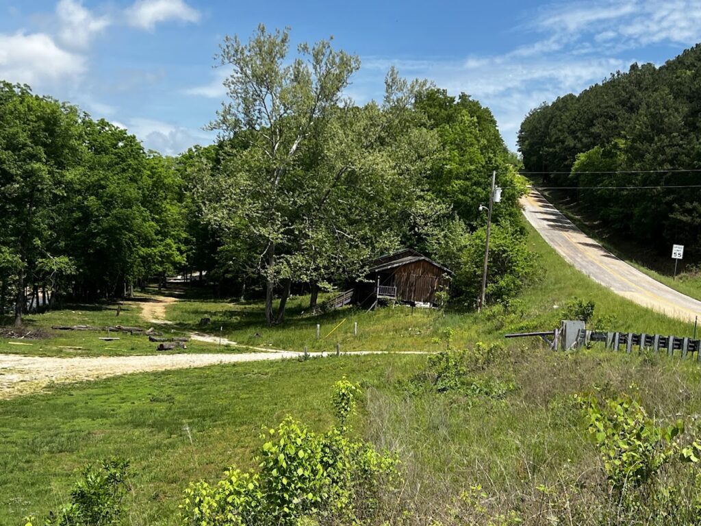 Distant view of rolling hills and a valley in the Ozark Mountains from a high point in Mark Twain National Forest. Appreciate the vastness and beauty of the Ozark landscape during your Ozark National Forest hiking and Mark Twain National Forest camping adventure.