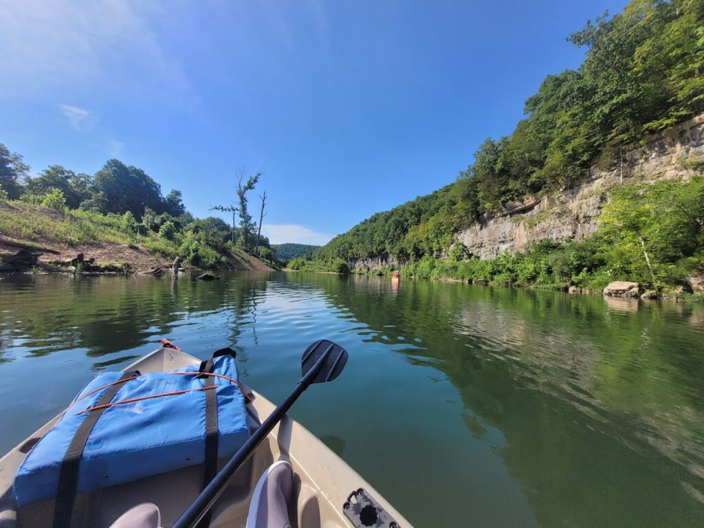 Kayaking on a clear river in Mark Twain National Forest. Embark on a thrilling Missouri River rafting Ozarks experience, paddling through pristine waters and enjoying nature's beauty.