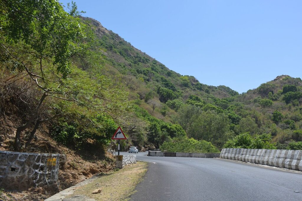 Scenic winding road approaching Mount Abu during hill-station season