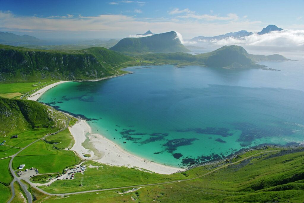 Haukland Beach: Easy access right off the E10. White sand, turquoise water, mountain backdrop.
