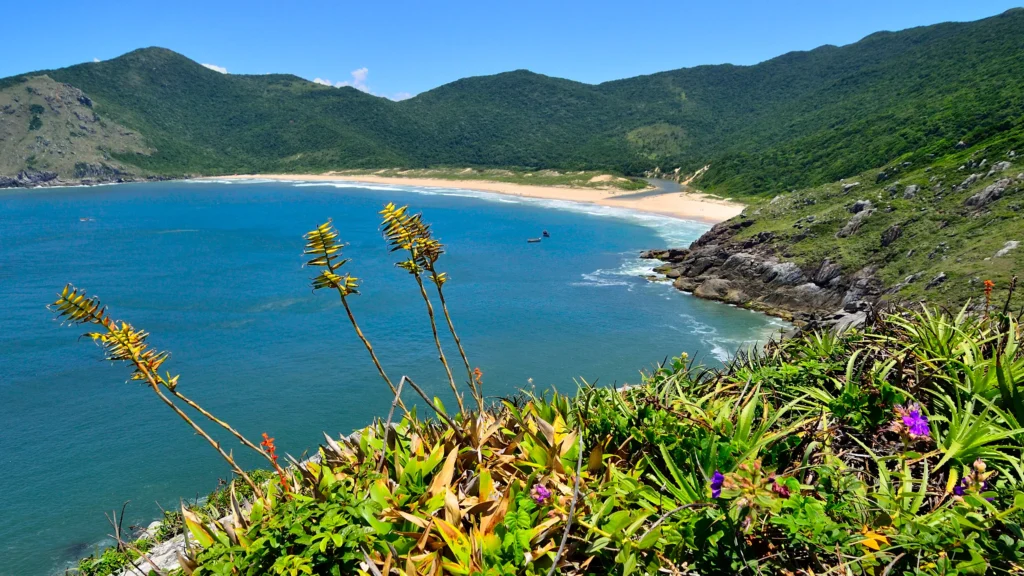 Turquoise sea, wide sandy beach and lagoon at Lagoinha do Leste with viewpoint in background